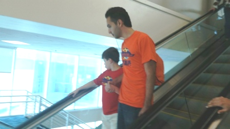 Staff with child going down escalator
